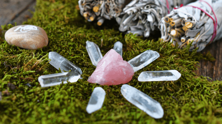 A crystal grid with clear and rose quartz, sage smudge and a reiki symbol